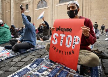 PENDUDUK Islam memegang sepanduk semasa berhimpun menentang Islamofobia di Rome, dua tahun lalu.-AFP