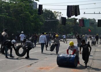 PENUNJUK perasaan menolak tayar untuk dijadikan halangan bagi memperlahankan pergerakan tentera dalam demonstrasi di Yangon, Myanmar. - AFP
