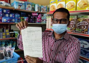 PEKEDAI runcit, Mansah Marjurin menunjukkan kompaun RM50,000 yang tidak mampu dibayar di kedainya di Jalan Chempaka, Kota Bharu, Kelantan, baru-baru ini.