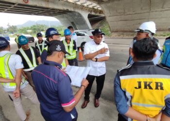 MUHAMMAD Fakhruddin Mohd. Ariff (kemeja putih, tengah) meninjau keadaan jalan rosak di laluan masuk ke kawasan perindustrian Semambu di Kuantan, Pahang. - FOTO/NORHAFIZAN ZULKIFLI