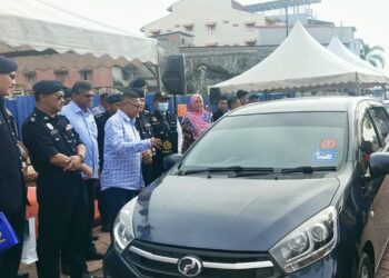 HANAFIAH Mat (tiga, kiri) memperkatakan sesuatu kepada seorang pemandu selepas melancarkan Kempen  Keselamatan Jalan Raya sempena Tahun Baharu Cina di  Pulau Warisan, Kuala Terengganu, hari ini. - UTUSAN/TENGKU DANISH BAHRI TENGKU YUSOFF