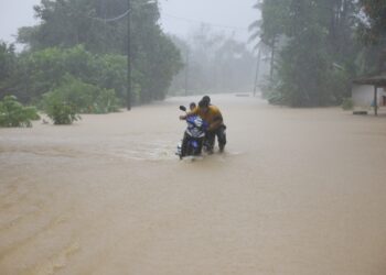 SEORANG penduduk dibantu dua anaknya menolak motosikal di sebatang jalan yang ditenggelami banjir di Kampung Tengkawang, Kuala Berang, Hulu Terengganu, Terengganu, hari ini. - UTUSAN/PUQTRA HAIRRY ROSLI