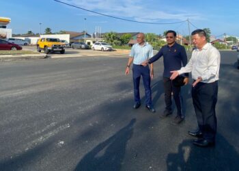 HAMDAN Hussin (tengah) dan Salehuddin Ishak (kiri) ketika melakukan tinjauan pembukaan Jalan Teluk Sisek di Kuantan, Pahang yang dibuka sepenuhnya kepada pengguna selepas ditutup hampir tiga tahun bagi memberi laluan kepada kerja-kerja pembentungan. - FOTO/NORHAFIZAN ZULKIFLI