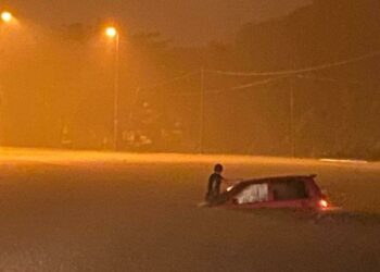 SEORANG pemandu kereta yang terkandas di sebatang jalan di Kampung Tanduk, Jerteh, Besut, malam tadi. - IHSAN APM