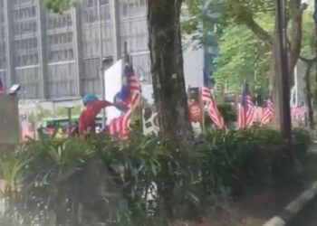 ANGKAP layar menunjukkan seorang lelaki menggunting Jalur Gemilang di tepi jalan berhampiran Pusat Pelancongan Malaysia (MaTiC) yang tular di TikTok sejak semalam. - MEDIA SOSIAL