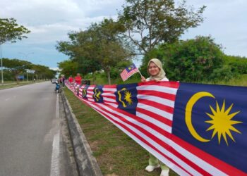 AHLI UMNO Bahagian Tangga Batu merentangkan Jalur Gemilang sepanjang 3.4 kilometer dari Jalan Pantai Kota Laksamana ke Klebang, Melaka. - UTUSAN/AMRAN MULUP