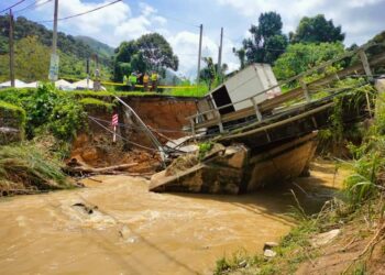 LORI muatan surat khabar dipandu lelaki berusia 30 tahun terperangkap dalam runtuhan jambatan Sungai Teras berdekatan Tokong Guan Yin, Kampung Tras di Raub, Pahang semalam. - IHSAN JKR RAUB