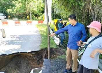 RAFLI MD. NOOR menunjukkan struktur Jambatan Enggor di Sungai Siput yang runtuh akibat arus deras semalam. - UTUSAN