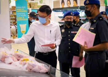 LEE Thing Han (kiri) memantau jualan ayam selepas melancarkan Skim Harga Maksimum Musim Perayaan Hari Raya Puasa 2022 di sebuah pasar raya di Johor Bahru.