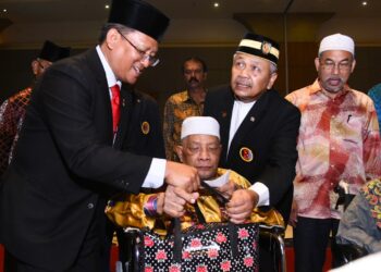 SHARUDDIN Omar (dua dari kanan) bersama Pengerusi Jawatankuasa Bertindak Pembangunan Belia dan Sukan Negeri Sembilan, Datuk Mohamad Taufek Abdul Ghani (kiri) menyerahkan sumbangan kepada seorang veteran tentera pada Majlis Makan Malam Amal 100 tahun Veteran di Seremban malam semalam. UTUSAN/ZAKKINA WATI AHMAD TARMIZI.