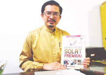 ROHIDZIR Rais menunjukkan buku Ensiklopedia Solat Premium yang ditulis oleh beliau di Port Dickson, Negeri Sembilan baru-baru ini.-