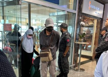 EMPAT jemaah umrah dari kumpulan tarekat terkandas di Arab Saudi dikawal ketat pihak berkuasa sejurus tiba di KLIA, Sepang. - IHSAN WISMA PUTRA