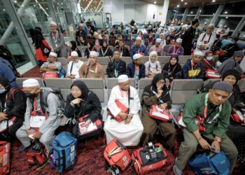 Jemaah haji menunggu giliran untuk berurusan di kaunter imigresen KLIA di Sepang semalam. - UTUSAN/MUHAMAD IQBAL