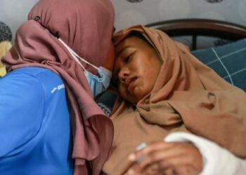 Roslinawati Ya memberi kata-kata semangat kepada Siti Nur Azizah Syafriadi di rumah mereka di PPR Beringin, Jinjang, Kuala Lumpur, semalam. UTUSAN/AFIQ RAZALI
