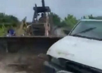 SEBUAH jengkaut melanggar kenderaan pacuan empat roda berikutan pertengkaran membabitkan sekumpulan individu dan dua beranak di kebun kelapa sawit di RTB Labu Kubong, Teluk Intan, baru-baru ini. - FOTO/MEDIA SOSIAL