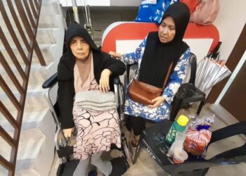 ZAINON Omar (kanan) bersama ibunya ketika ditemui di PPS di Dewan Muafakat TDU, Kota Tinggi.