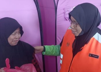 SITI Zailah Mohd. Yusof berbual dengan mangsa banjir yang ditempatkan di PPS SMK Seri Gading, Batu Pahat, Johor.