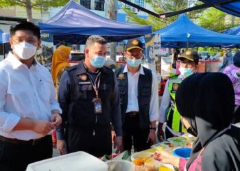 DR. MOHD. Ridzuan Mohd. Lutpi (dua dari kiri) memeriksa tahap kebersihan peniaga dan premis semasa operasi dijalankan PKD Muar bersama MPM di Bazar Ramadan Kampung Tengah, Sungai Abong, Muar, Johor. - FOTO/NUR ALINA HASSAN
