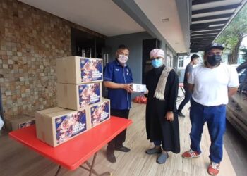 Che Zakaria Mohd. Salleh (kiri) menyampaikan sumbangan JKM kepada penduduk Flat 64, Bandar Baru Seri Alam, hari ini.