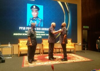 MOHAMMAD Hamdan Wahid (tengah) memakaikan Pingat Ketua Pengarah Bomba kepada Timbalan Pengarah JBPM Johor, Pauzan Ahmad pada Majlis Penganugerahan Pingat Kebesaran Jabatan dan Anugerah Perkhidmatan Cemerlang 2020 di Johor Bahru. -UTUSAN/MOHAMAD FAIZAL HASHIM