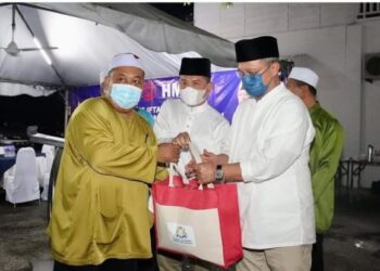 HASNI Mohammad (kanan) menyampaikan sumbangan kepada Ketua-Ketua UMNO Cawangan pada Majlis Iftar UMNO Bahagian Pontian di Dewan UMNO Pontian, Johor. - FOTO/MUHAMMAD ZIKRI