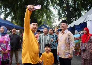 HASNI Mohammad (kanan) berswafoto bersama orang ramai yang menghadiri rumah terbuka Hari Raya Aidilfitri ADUN Pulai Sebatang, Hasrunizah Hassan di Dewan UMNO, Pontian, di sini.