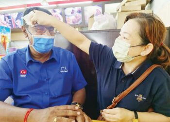 LEE Sok Fong mengelap peluh di dahi S. Suppayah selepas mereka keluar berkempen di sekitar DUN Bukit Batu, Kulai, Johor.