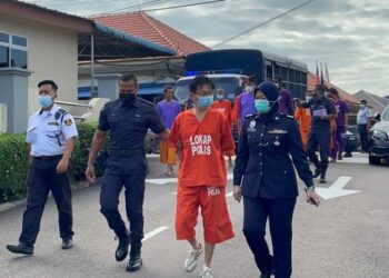 LIM Lai Kok (dua kanan) diiringi anggota polis selepas dipenjara enam tahun kerana kesalahan menggunakan wang palsu di Mahkamah Sesyen Kluang, Johor. -UTUSAN/NUR NABILAH RAHMAT