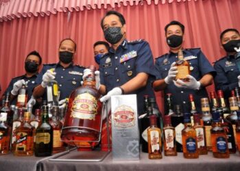 SAZALI Mohamad (lima dari kiri) menunjukkan minuman keras yang diseludup dipercayai bagi mengelak cukai pada sidang akhbar di Menara Kastam di Johor Bahru. -UTUSAN/RAJA JAAFAR ALI