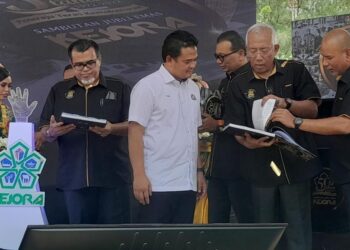 MAHDZIR Khalid (dua kanan) melihat buku pencapaian Kejora selama 50 tahun ketika merasmikan Sambutan Jubli Emas Ulang Tahun Ke-50 Kejora di Dataran Tanjung Balau, Bandar Penawar hari ini. -UTUSAN/MASTURAH SURADI