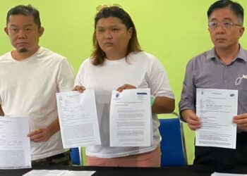 MICHELLE Kim (tengah) menunjukkan laporan polis yang dibuat pihaknya bagi meminta penjelasan berhubung kematian abangnya yang ditahan di Penjara Kluang pada 28 Jun lalu.