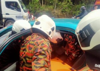 ANGGOTA bomba mengeluarkan mangsa kemalangan yang tersepit di Kilometer 14, Jalan Muar-Yong Peng berhampiran Kampung Sri Jasa di Yong Peng. - FOTO/IHSAN BOMBA