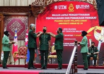 ZAMROSE Mohd. Zain (kiri) memakaikan pangkat pada Majlis Lafaz Pengisytiharan Pentauliahan dan Pemakaian Pangkat Pegawai Kadet Palapes Darat Universiti Awam Ke-39 di Universiti Teknologi Malaysia (UTM), Skudai di Johor.