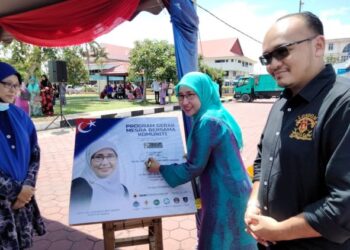 HASRUNIZAH Hassan menandatangani plak perasmian Program Gerak Mesra anjuran bersama beberapa agensi kerajaan di Dataran Pontian, di sini.