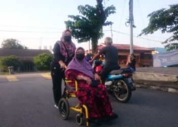 FATEMAH Atan bersama anaknya, Norhafizah Sain hadir ke pusat mengundi bagi menunaikan kewajipan di Dewan Kampung Melayu, Johor Bahru.