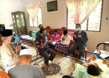 AHMAD Maslan (tengah) membaca doa ketika melawat seorang ketua kampung yang terlibat kemalangan di Kampung Parit Haji Ahmad, Ayer Baloi di Pontian, hari ini. -UTUSAN/MUHAMMAD ZIKRI