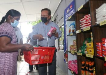 HASNI Mohammad (kanan) membantu salah seorang penerima mengambil keperluan asas yang diberikan kerajaan negeri menerusi program Gobok Rakyat Johor di Pejabat Penghulu Mukim Jelutong, Gelang Patah, di Johor.
