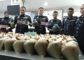 AHMAD Zamry Marinsah (tiga dari kiri) menunjukkan air ketum yang dirampas dalam serbuan di sebuah pondok di Kampung Tengah, Segamat.