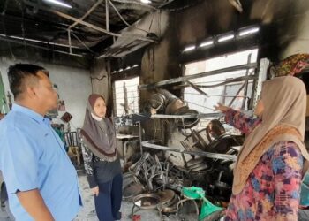 SUZILAWATI Abdullah (dua dari kiri) bersama ibunya, Jelimah Yahya (kanan) menunjukkan barang-barang perniagaannya yang musnah kepada Ketua Kampung Felda Sungai Mas, Nizam Ali ketika melawat rumah mereka terbakar.