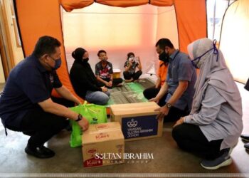 DAVID Wong (kiri) dan Azmi Rohani (dua kanan) menyampaikan bantuan Sultan Johor kepada mangsa ribut di PPS Sekolah Kebangsaan Seri Setia Jaya, Tanjung Sedili, Kota Tinggi di Johor.