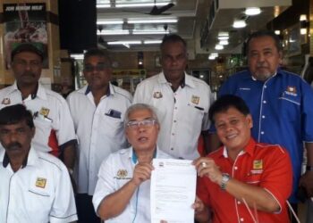 HASSAN Abdul Karim (tengah) menerima surat permohonan sumbangan daripada Rahman untuk aktiviti persatuan teksi di Permas Jaya, Johor Bahru.