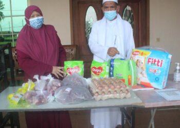 PESARA kerajaan, Mohd. As’ari Tibek (kanan) dan Faredah Mashhor bersama barangan keperluan harian yang disediakan Lemarikasih di rumah mereka di Jalan Dato Ali, Pontian, Johor.