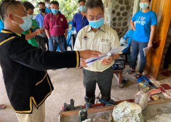 DR. JOACHIM Gunsalam diberi penerangan oleh , Pengerusi Persatuan Kinabalu Jade Eco Tourism, Jirus Muin (kanan) ketika melawat pameran  Kraftangan Jed Kinabalu di Kampung Nalumad, Ranau,