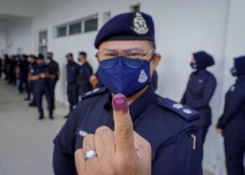 Ketua Polis Daerah Kota Tinggi, Superintenden Hussin Zamora menunjuk jarinya yang sudah dicelup dengan dakwat kekal selepas menunaikan tanggungjawab mengundi awal pada Pilihan Raya Negeri (PRN) Johor di Bilik Gerakan Ibu Pejabat Polis Daerah (IPD) Kota Tinggi pada Selasa. - UTUSAN/FARIZ RUSADIO