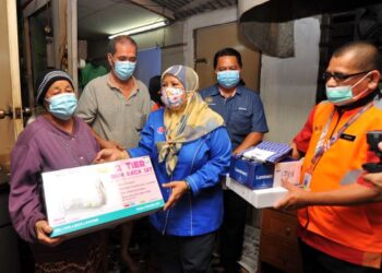 ZAITON Ismail (dua dari kanan) menyampaikan sumbangan kepada warga emas, Azizah Omar sambil diperhatikan Mohamad Hapil (kanan) ketika melawat dan menyampaikan sumbangan  di Kampung Kempas Baru, Johor. - UTUSAN/RAJA JAAFAR ALI