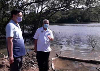 JIMMY Puah Wee Tse (kiri) bersama Hassan Abdul Karim meninjau keadaan Sungai Kim Kim, Pasir Gudang, Johor, semalam