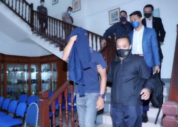 AHMAD JAMIL Md. Saru (menutup muka) mengaku tidak bersalah atas tuduhan rasuah selepas dihadapkan ke Mahkamah Sesyen, Ayer Keroh, Melaka hari ini. - UTUSAN/RASUL AZLI SAMAD