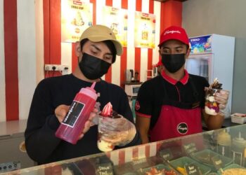 MOHAMAD Hafizuddin (kiri) bersama pekerjanya menunjukkan aiskrim yogurt di kafenya yang terletak di Bandar Baru Kubang Kerian, Kota Bharu. - UTUSAN/ROSLIZA MOHAMED