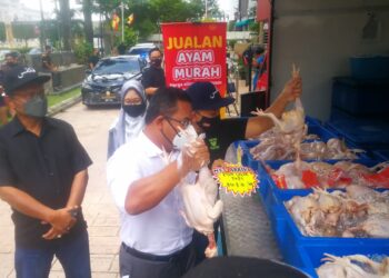 AMIRUDIN Shari mengangkat ayam segar yang dijual pada harga RM8 sekilogram di Wisma PKPS di Shah Alam, Selangor, hari ini. - UTUSAN / ABDUL RAZAK IDRIS