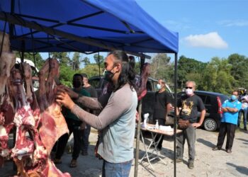 SHAHFUANNIZAM Zolkifly menyediakan daging segar untuk dijual kepada orang ramai di Kampung Sentosa, Seremban, Negeri Sembilan. - UTUSAN/BADRUL HAFIZAN MAT ISA